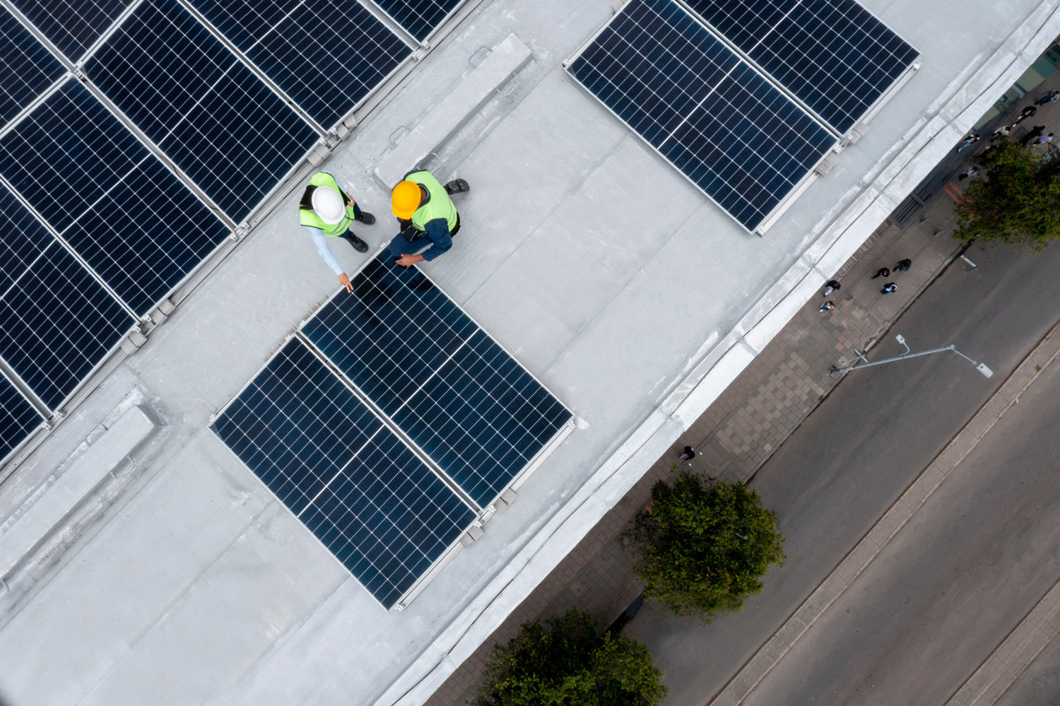 iStock-1493545275 Un team di ingegneri valuta il progetto durante l'installazione di un impianto fotovoltaico su una struttura commerciale.
